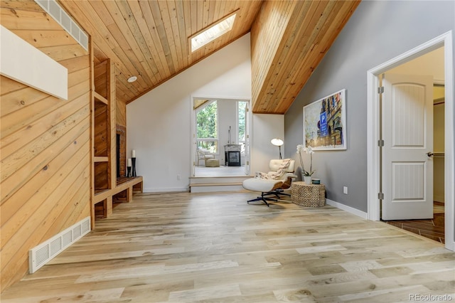 sitting room with a skylight, visible vents, wood ceiling, wood finished floors, and high vaulted ceiling