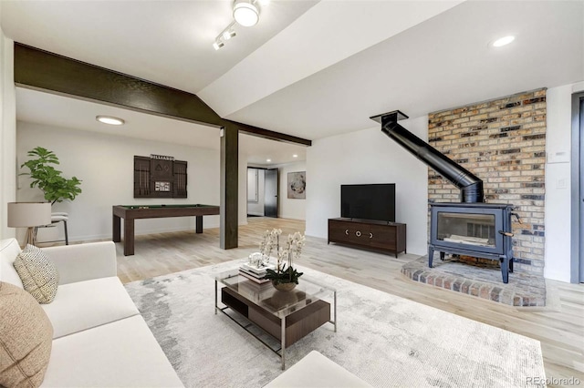 living room with lofted ceiling with beams, pool table, wood finished floors, and a wood stove