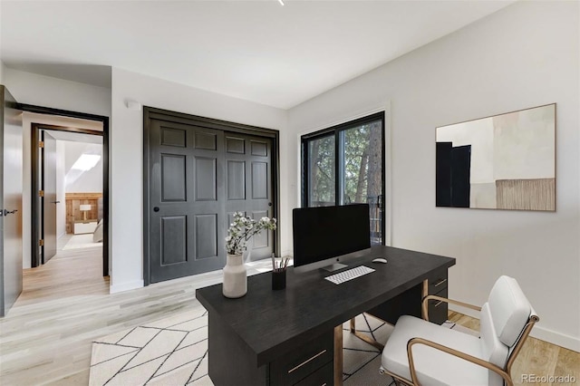 office area featuring light wood-type flooring and baseboards