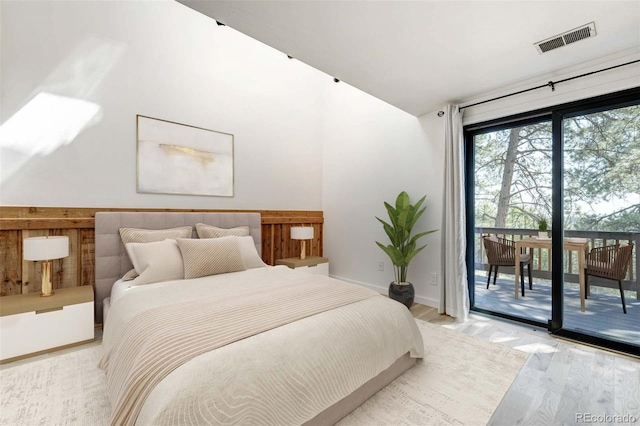 bedroom featuring light wood finished floors, access to outside, visible vents, and baseboards