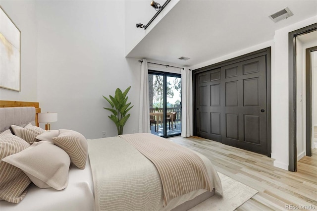 bedroom featuring baseboards, light wood-style flooring, visible vents, and access to exterior