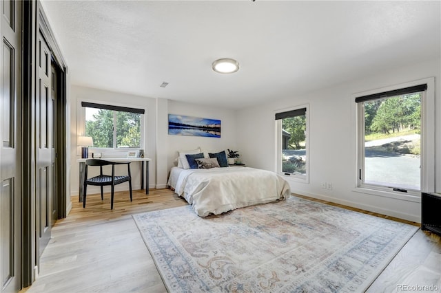 bedroom featuring light wood-style floors and baseboards