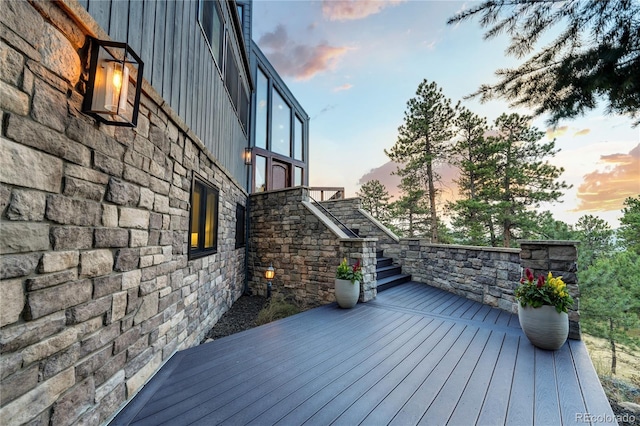 deck at dusk featuring stairs