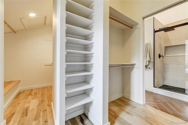 spacious closet featuring wood finished floors and attic access