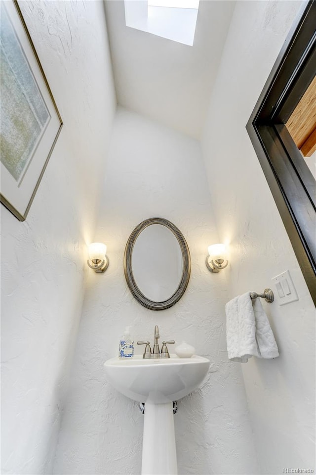 bathroom with a textured wall and a sink