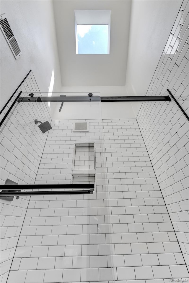 room details featuring tiled shower and visible vents