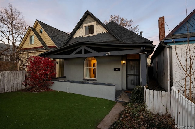 view of front facade featuring covered porch and a lawn