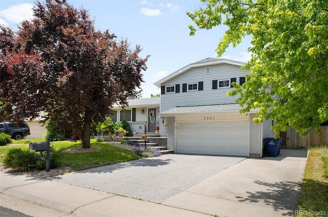 7371 Otis Ct, Arvada, CO 80003 - split level home with asphalt driveway, a garage, brick siding, and roof with shingles