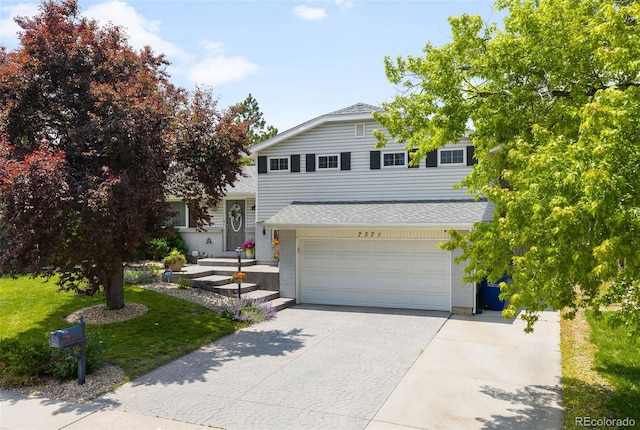 7371 Otis Ct, Arvada, CO 80003 - view of front facade featuring driveway, a garage, a front lawn, roof with shingles, and brick siding