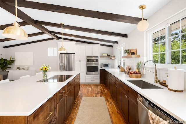 7371 Otis Ct, Arvada, CO 80003 - kitchen with stainless steel appliances, a sink, wood finished floors, light countertops, and open shelves