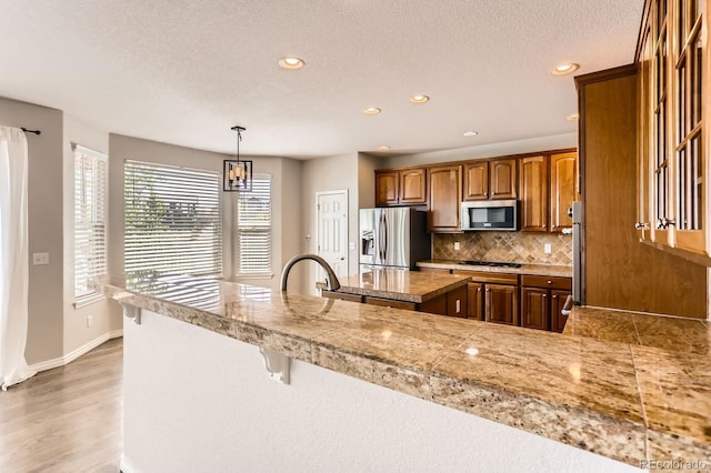 1905 Graphite Ct, Castle Rock, CO 80108 - kitchen with stainless steel appliances, tile countertops, recessed lighting, tasteful backsplash, and a textured ceiling