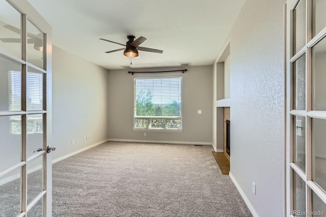 1905 Graphite Ct, Castle Rock, CO 80108 - spare room with carpet flooring, ceiling fan, a fireplace with flush hearth, and french doors
