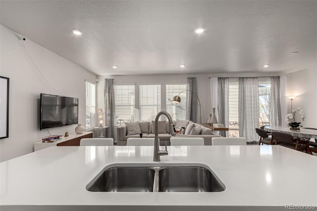 kitchen featuring a textured ceiling, a healthy amount of sunlight, and sink