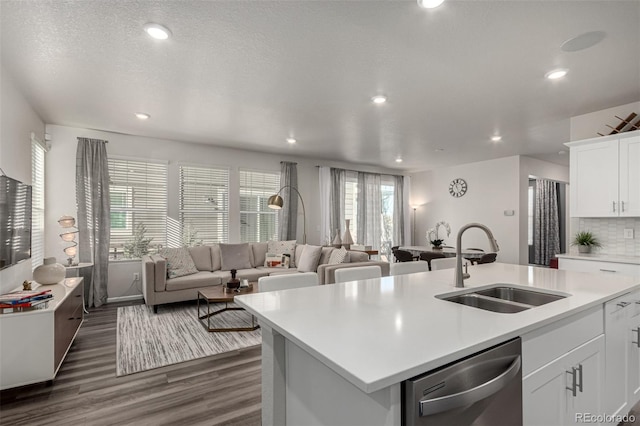 kitchen with dishwasher, sink, a kitchen island with sink, decorative backsplash, and white cabinets