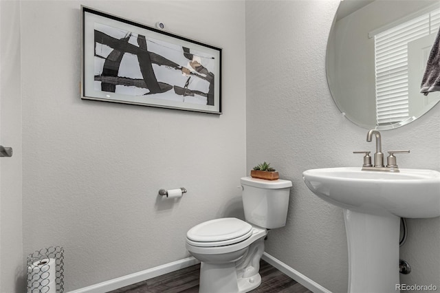 bathroom featuring toilet, wood-type flooring, and sink