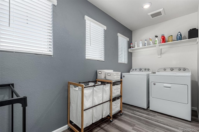 laundry area with hardwood / wood-style floors and washing machine and clothes dryer