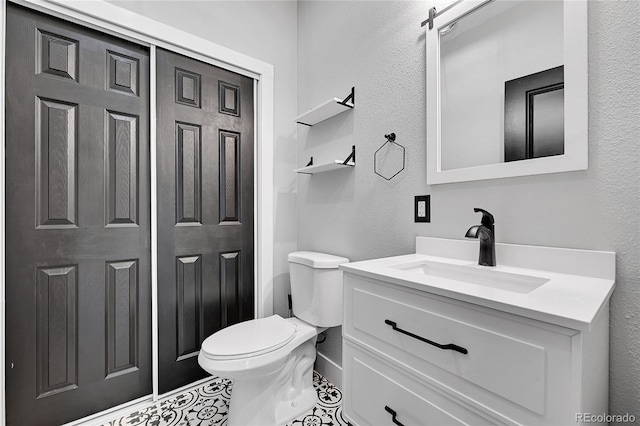 bathroom featuring toilet, tile patterned floors, and vanity