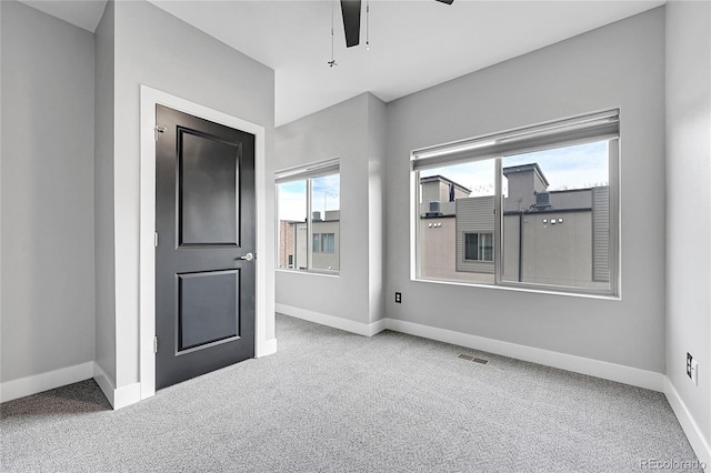 empty room with ceiling fan and carpet