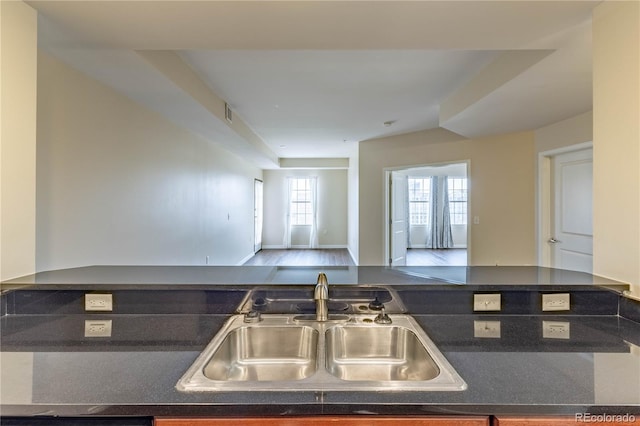 kitchen with open floor plan, dark countertops, and a sink