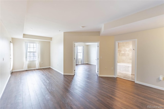 spare room with dark wood finished floors and baseboards