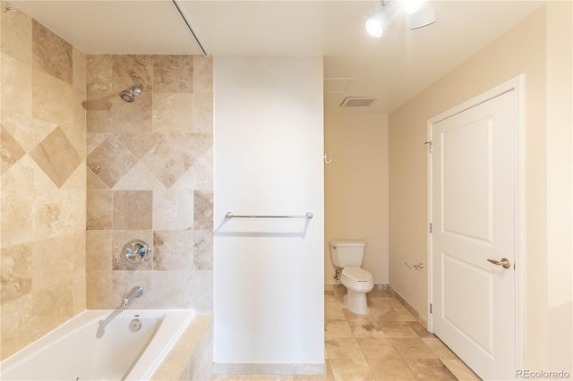 bathroom with toilet, baseboards, visible vents, and tiled shower / bath combo