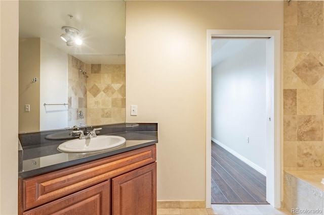 full bathroom featuring a shower, a washtub, vanity, and baseboards