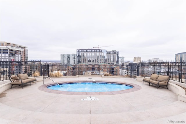 view of pool with a view of city and a patio area