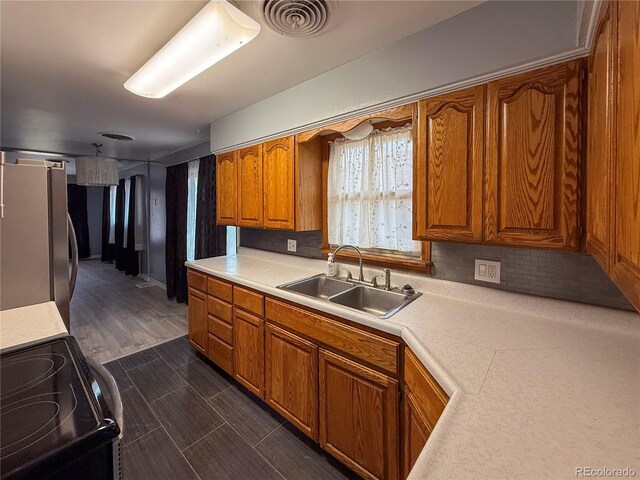 163 Pomeroy St, Burlington, CO 80807 - kitchen featuring fridge, electric stove, light countertops, and brown cabinets
