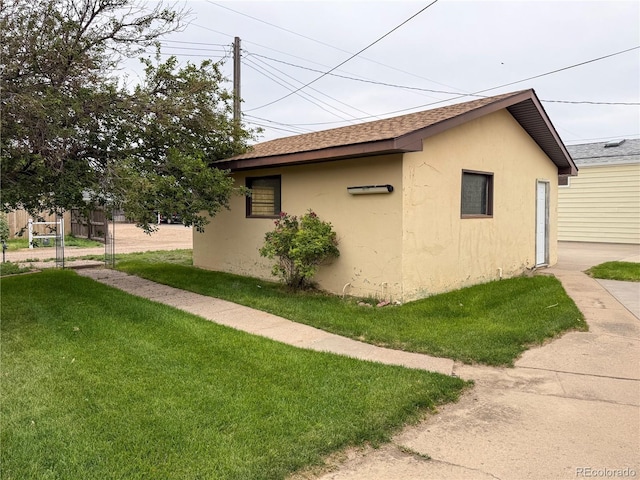163 Pomeroy St, Burlington, CO 80807 - view of home's exterior with stucco siding, a yard, and roof with shingles