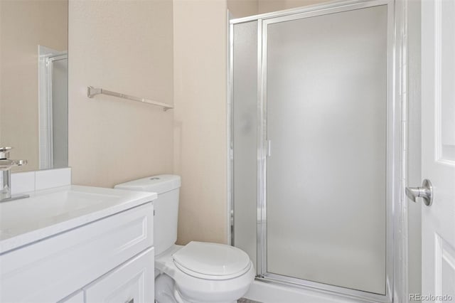 bathroom featuring vanity, an enclosed shower, and toilet