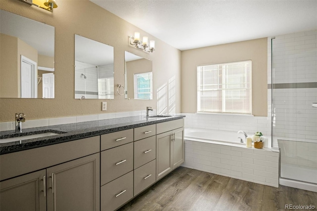 bathroom with vanity, wood-type flooring, and shower with separate bathtub