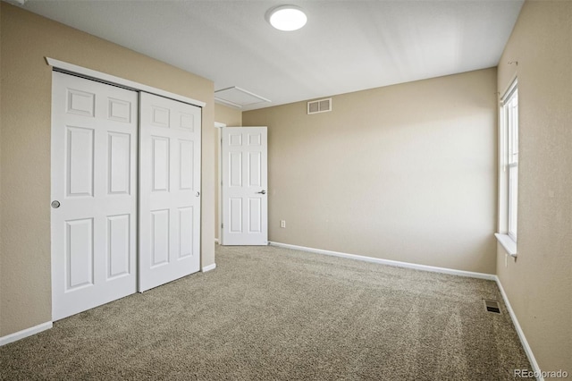 unfurnished bedroom with multiple windows, carpet, and a closet