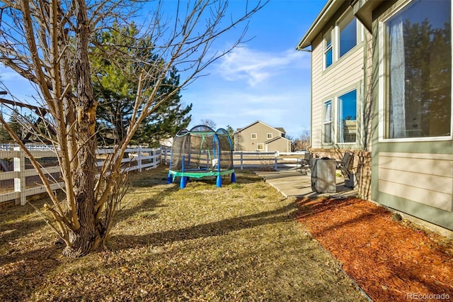 view of yard featuring a trampoline and a patio area