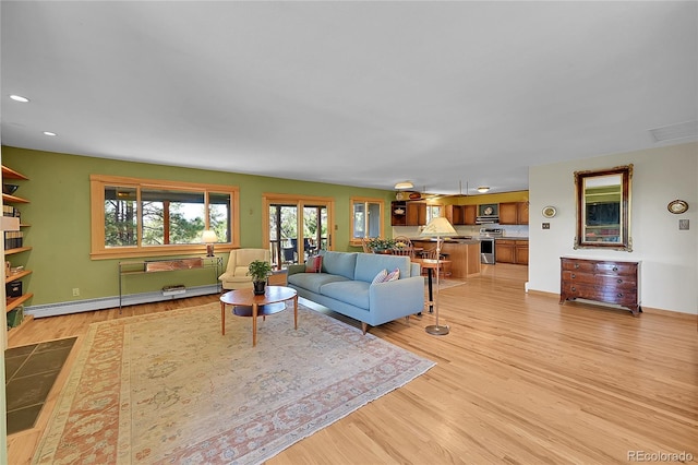 living room with baseboard heating and light hardwood / wood-style flooring