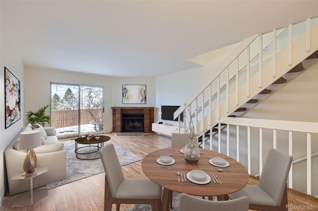 dining area featuring a brick fireplace and hardwood / wood-style floors