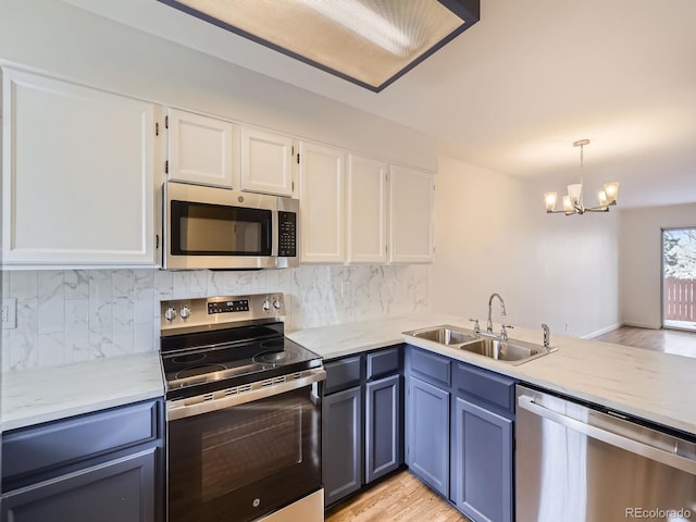 kitchen with appliances with stainless steel finishes, decorative light fixtures, and white cabinets