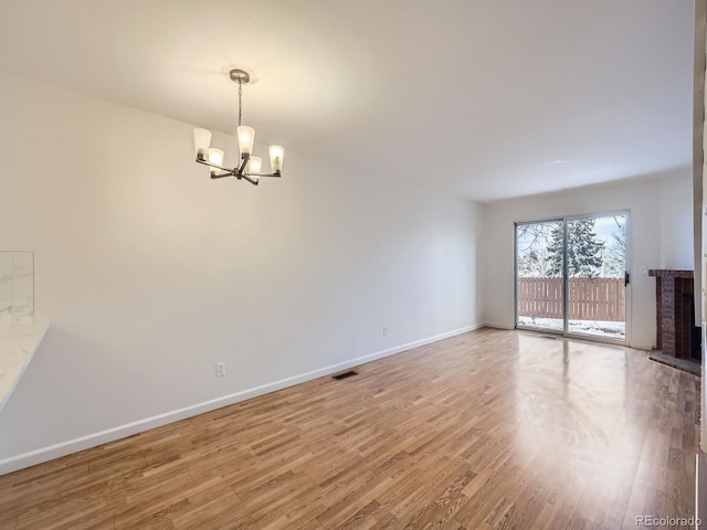 unfurnished living room with hardwood / wood-style floors and a chandelier