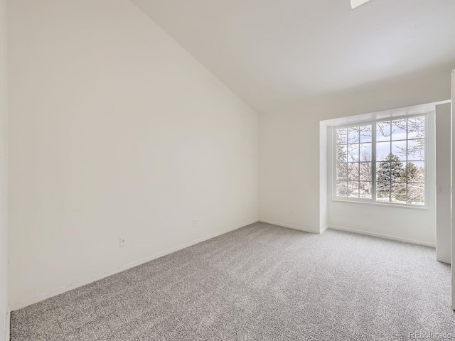 empty room featuring vaulted ceiling and carpet flooring