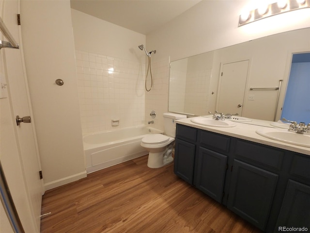 full bathroom featuring vanity, hardwood / wood-style floors, toilet, and tiled shower / bath