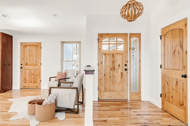 foyer entrance with recessed lighting, light wood-type flooring, and a notable chandelier