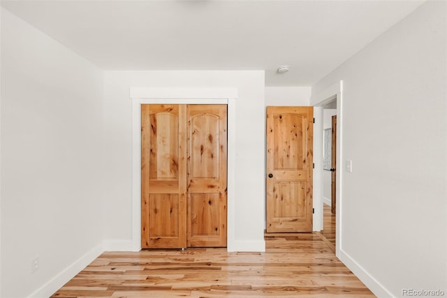 unfurnished bedroom with baseboards and light wood finished floors