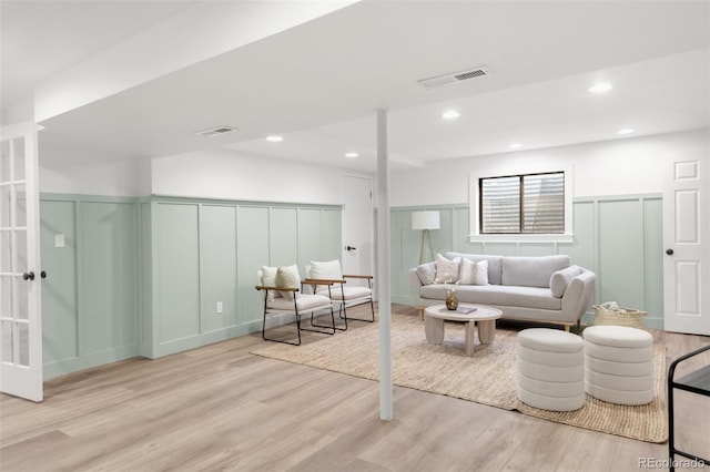 living room with recessed lighting, wood finished floors, and visible vents