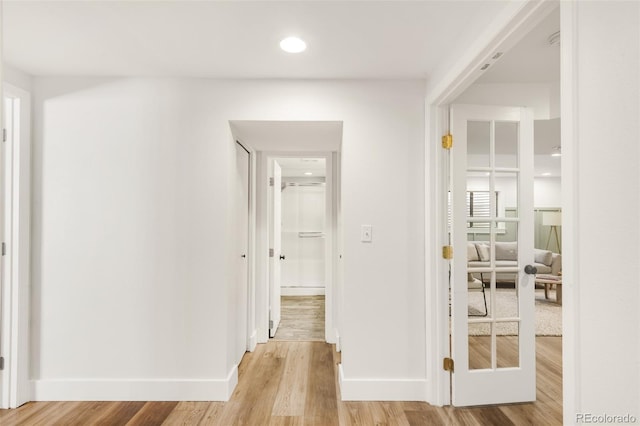 hall featuring baseboards and light wood-style floors