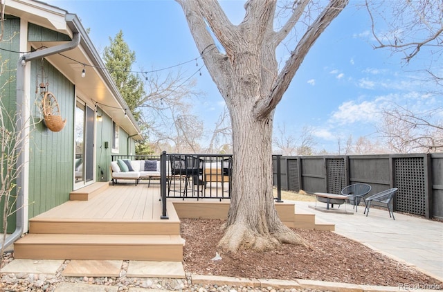 wooden terrace with a patio area, an outdoor hangout area, and fence