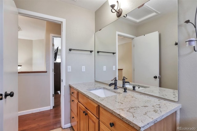 12333 Newport Ct, Brighton, CO 80602 - bathroom with wood finished floors, vanity, and baseboards