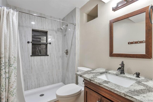 12333 Newport Ct, Brighton, CO 80602 - bathroom featuring toilet, tiled shower, and vanity