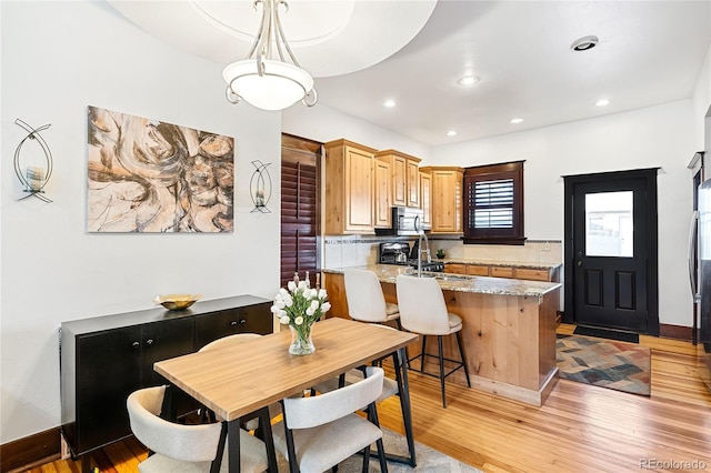 dining space with sink and light wood-type flooring