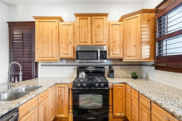 kitchen featuring sink, decorative backsplash, light stone countertops, and appliances with stainless steel finishes