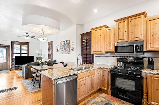 kitchen featuring sink, light hardwood / wood-style flooring, stainless steel appliances, and kitchen peninsula