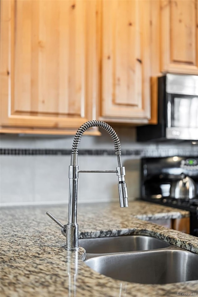 room details featuring light brown cabinetry and sink